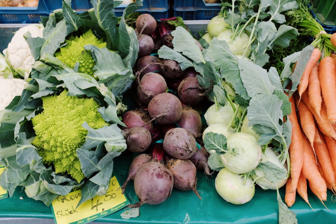 assorted fresh ripe vegetables in market stall